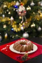 Christmas or New Year chocolate cake with powdered sugar on the top, fresh red berries on white porcelain plate