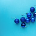 Christmas or new year composition with blue balls on colored background, top view