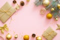 Christmas or New year composition. Christmas presents, ribbon, golden balls, fir tree branches on pastel pink background. Flat lay