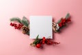 Christmas and new year composition. Creative layout made of paper blank on pink background. Fir tree branches, red berry and decor Royalty Free Stock Photo