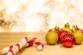 Christmas or new year composition. Christmas decorations in gold and red balls on wood. Light bokeh background. Royalty Free Stock Photo