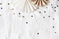 Christmas, New Year composition. Decorative paper stars, golden and black confetti on white linen tablecloth background Royalty Free Stock Photo