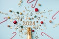 2024 christmas and New Year composition with champagne bottle, fir tree, party streamers, confetti stars and decorations. Flat lay Royalty Free Stock Photo