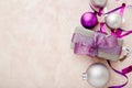 Christmas or New Year composition. Xmas purple and silver decorations: ribbons and balls on pink pastel background. Flat lay, top Royalty Free Stock Photo