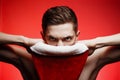 Christmas new year concept. Man with santa claus hat looking angry. Dangerous Guy with stylish hair on red background with