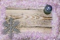 Christmas and New Year Concept. wooden board in a frame of brilliant artificial snow and New Year`s balls, Top view, flat lay Royalty Free Stock Photo