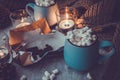 Christmas and New Year cozy holiday composition with cinnamon, candles, scarf, chocolate, pine cone, mugs with cocoa or