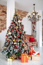 Christmas and New Year decorated interior room with red presents and New year tree and classic brown sofa in front of Royalty Free Stock Photo