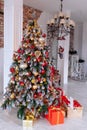 Christmas and New Year decorated interior room with red presents and New year tree in front of white wall. Royalty Free Stock Photo