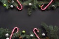 Christmas or New Year decoration background: fir-tree branches, colorful balls, candy on black background with copy space. Top vie Royalty Free Stock Photo