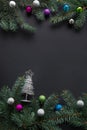 Christmas or New Year decoration background: fir-tree branches, colorful glass balls on black grunge background with copy space. Royalty Free Stock Photo