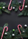 Christmas or New Year decoration background. Fir tree branches, spruce, candy, colorful balls on black background with copy space. Royalty Free Stock Photo