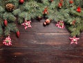 Christmas or New Year decoration background: fur-tree branches, colorful glass balls and glittering stars on wooden Royalty Free Stock Photo