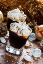 Christmas or New Year decoration and black coffee in small glasses with marshmallows, cinnamon and icing sugar