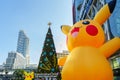 Christmas and New Year decoration design with Pikachu Pokemon theme, Japanese cartoon, with background of large Christmas tree in