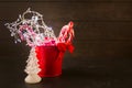 Christmas or New Year decorations - red bucket with garland, candy canes, bow and christmas tree Royalty Free Stock Photo