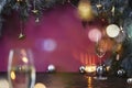 Christmas New Year eve mood with fir tree, champagne in glasses, decoration on dark wooden board, glare of light on background Royalty Free Stock Photo