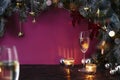 Christmas New Year eve mood with fir tree, champagne in glasses, decoration on dark wooden board, glare of light on background Royalty Free Stock Photo