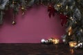 Christmas New Year eve mood with fir tree, decoration, balls on dark wooden board, violet background Royalty Free Stock Photo