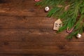 Christmas or New Year flat lay decoration background: cypress branches, wooden house, candy cane, on dark wooden background