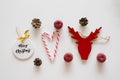 Christmas and new year flat lay. Red Christmas tree toy in the form of a deer, lollipops, cones and apples Royalty Free Stock Photo