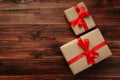 Christmas and new year with gift boxes wrapped with kraft brown paper and red ribbon on wooden table background Royalty Free Stock Photo