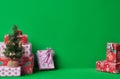 Christmas and New Year green background with present and small xmas tree for card invitation