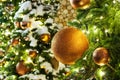 Christmas or New Year greeting card, golden christmas decorations glass balls on green pine branches, white snow and shiny lights Royalty Free Stock Photo