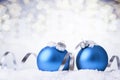 Christmas and New Year greeting card. Holiday ornament, winter decoration. Blue christmas balls with silver ribbon in snow over Royalty Free Stock Photo