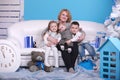 Christmas and new year holiday. grandmother with her little grandsons and granddaughter on a white sofa near christmas tree and Royalty Free Stock Photo