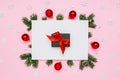 Christmas, New Year holiday layout. Black gift box with red bow in frame of natural fir tree branches and decorations on