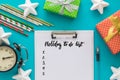 Christmas and New Year holiday to do list with notepad, pen, gift boxes, clock, cocktail tubes, stars on the blue Royalty Free Stock Photo