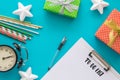 Christmas and New Year holiday to do list with notepad, pen, gift boxes, clock, cocktail tubes, stars on the blue Royalty Free Stock Photo