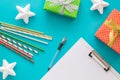 Christmas and New Year holiday to do list with notepad, pen, gift boxes, cocktail tubes, stars on the blue background Royalty Free Stock Photo