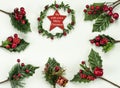 Christmas New Year holidays composition: green holiday wreath with red star, 7 green branches, red berries and gift Royalty Free Stock Photo