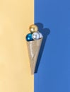 Christmas and new year holidays shiny ice cream cone filled with golden, silver and blue baubles Royalty Free Stock Photo