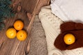 Christmas and New Year Mandarins crocheted, brown gloves on the background of colorful, warm sweaters