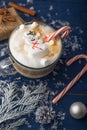 Christmas and New Year. Marshmallow snowman in hot latte in a mug. Vertical photo