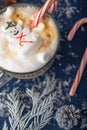 Christmas and New Year. Marshmallow snowman in hot latte in a mug. Vertical photo