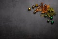 Christmas and New Year minimalism composition. Green and orange decorations in the form of flowers and balls on a dark b