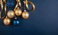 Golden and blue Glass Balls hanging on ribbon on Navy blue background with copy space for text Royalty Free Stock Photo