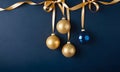 Golden and blue Glass Balls hanging on ribbon on Navy blue background with copy space for text Royalty Free Stock Photo