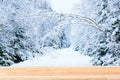Christmas or New Year mockup theme. Winter forest landscape with a road and empty light brown wooden table