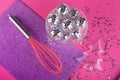 Christmas, New year party concept. Sparky silver disco balls in glass transparent plate, pink kitchen whisk and small stars, pine