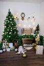 Christmas and New Year photo studio, green tree, soft chair, garlands stars, clock on a white wall (2). Royalty Free Stock Photo