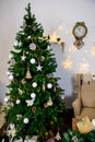 Christmas and New Year photo studio, green tree, soft chair, garlands stars, clock on a white wall (4).