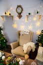 Christmas and New Year photo studio, green tree, soft chair, garlands stars, clock on a white wall (6). Royalty Free Stock Photo