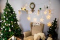 Christmas and New Year photo studio, green tree, soft chair, garlands stars, clock on a white wall (8). Royalty Free Stock Photo