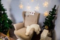 Christmas and New Year photo studio, green tree, soft chair, garlands stars, plush toy, white wall (2). Royalty Free Stock Photo