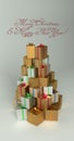 Christmas and New Year presents in the pile with the shape of the Christmas tree. With red greeting text.